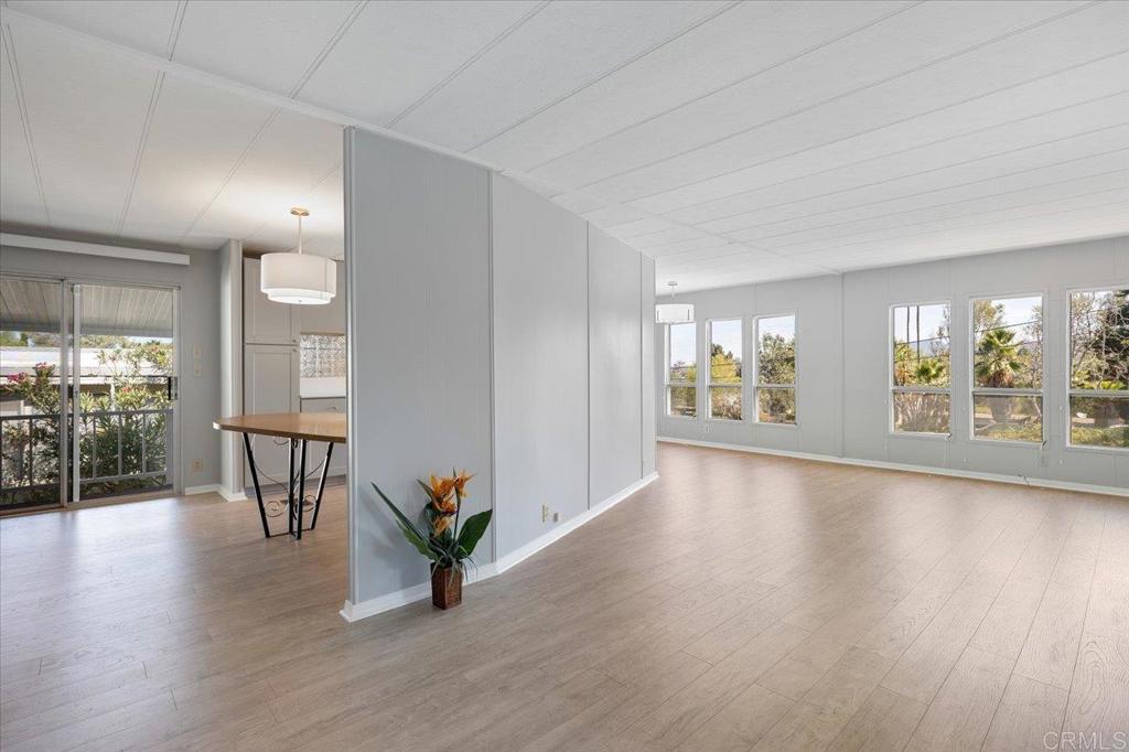 an empty room with wooden floor and a floor to ceiling window