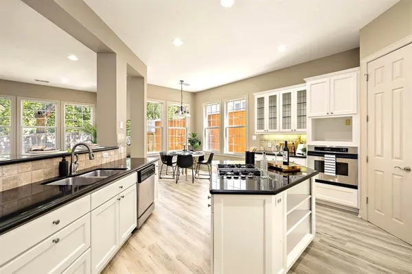 a kitchen with counter top space a sink cabinets and living room view