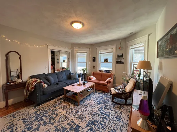 a living room with furniture a rug and a lamp