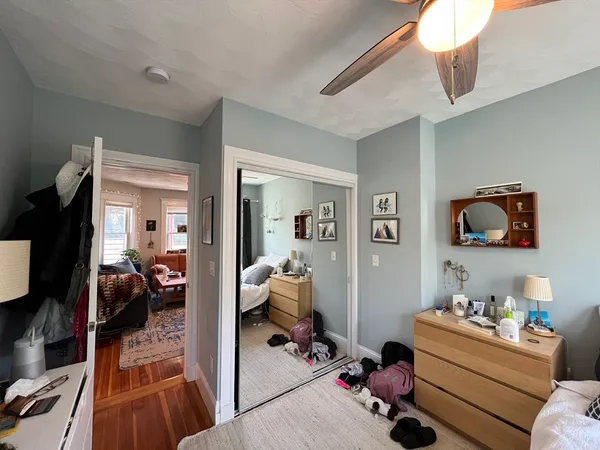 a room with a baby bed furniture and a flat tv screen