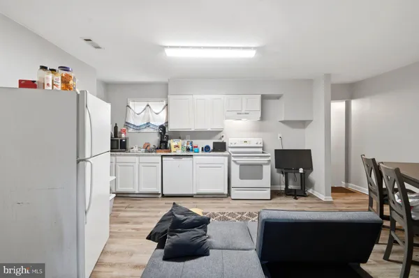 a kitchen with stainless steel appliances granite countertop a refrigerator sink and white cabinets