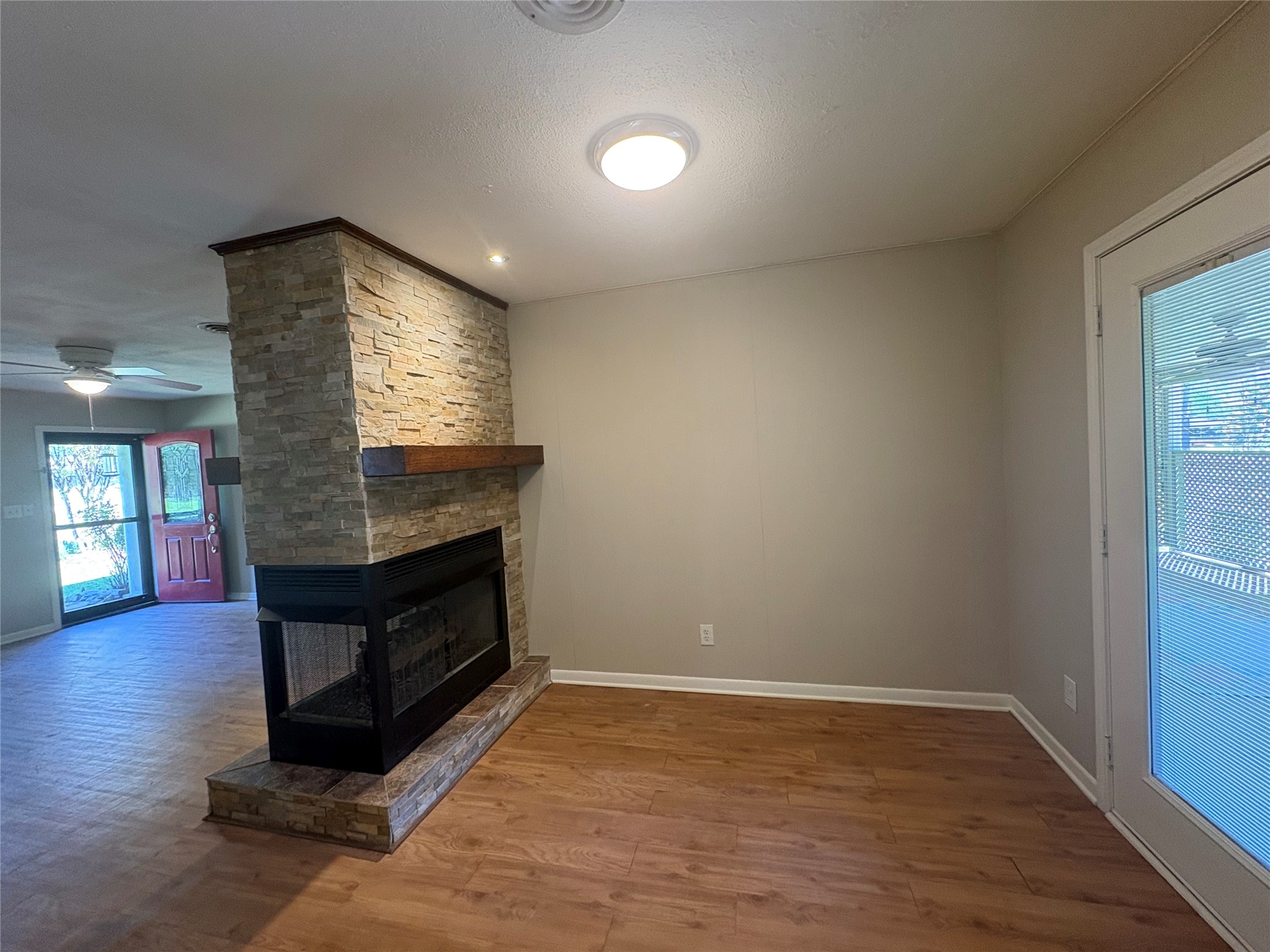 101 Pine Shadows Lane Coldspring, TX 77331 - Photo 4 of 10 This cozy breakfast area features a stone fireplace as a focal point and ample natural light from a nearby patio door, creating an inviting atmosphere.