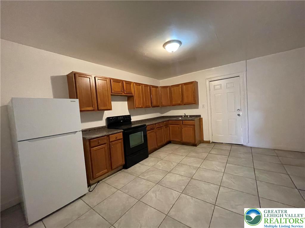 636 Ridge Avenue Allentown, PA 18102 - Photo 4 of 10 a kitchen with a refrigerator a stove top oven and cabinets