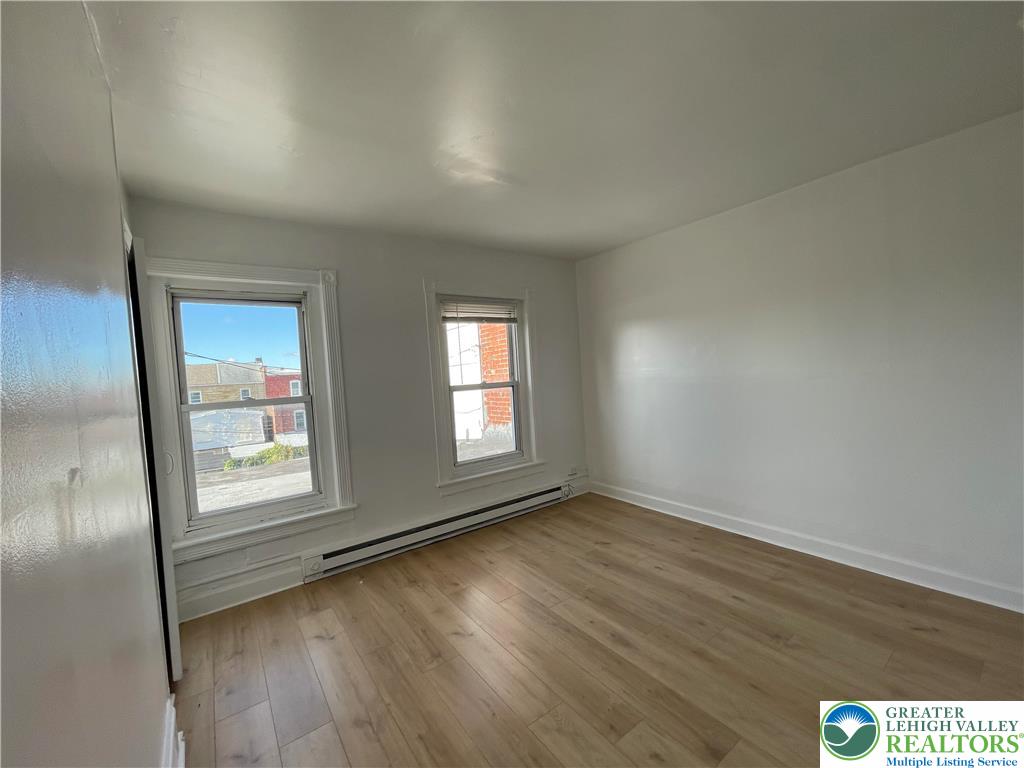 636 Ridge Avenue Allentown, PA 18102 - Photo 9 of 10 an empty room with wooden floor and windows