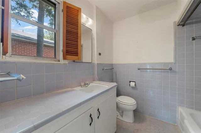 a bathroom with a toilet a sink and a mirror