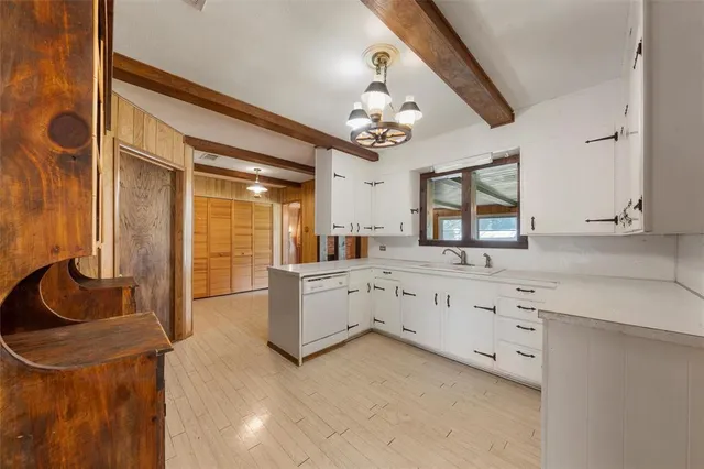 a large white kitchen with cabinets