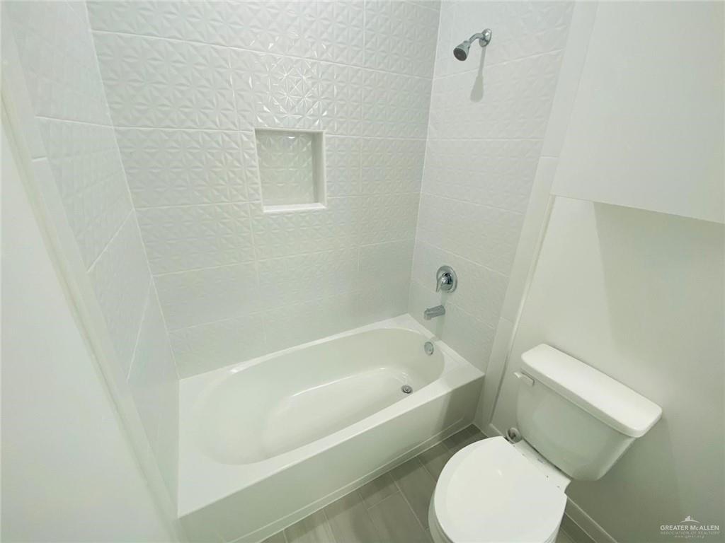 1623 West Marlin Street, Unit 3 Pharr, TX 78577 - Photo 6 of 9 a white toilet sitting next to a bath tub