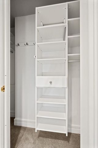 a view of walk in closet with empty racks