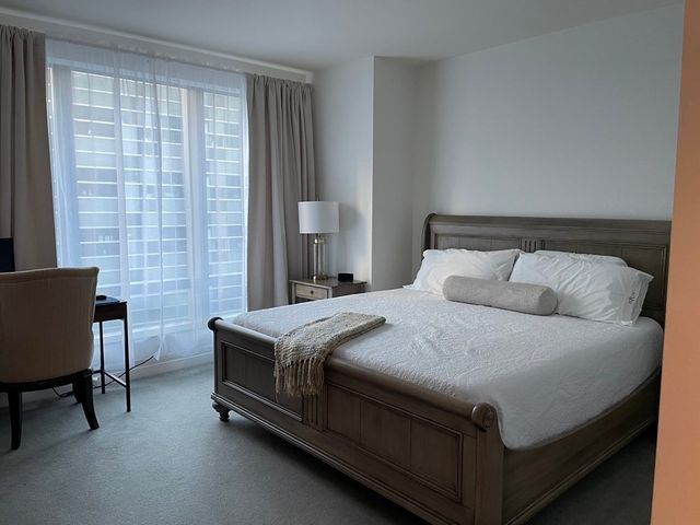 a bedroom with a bed chair and a lamp on table