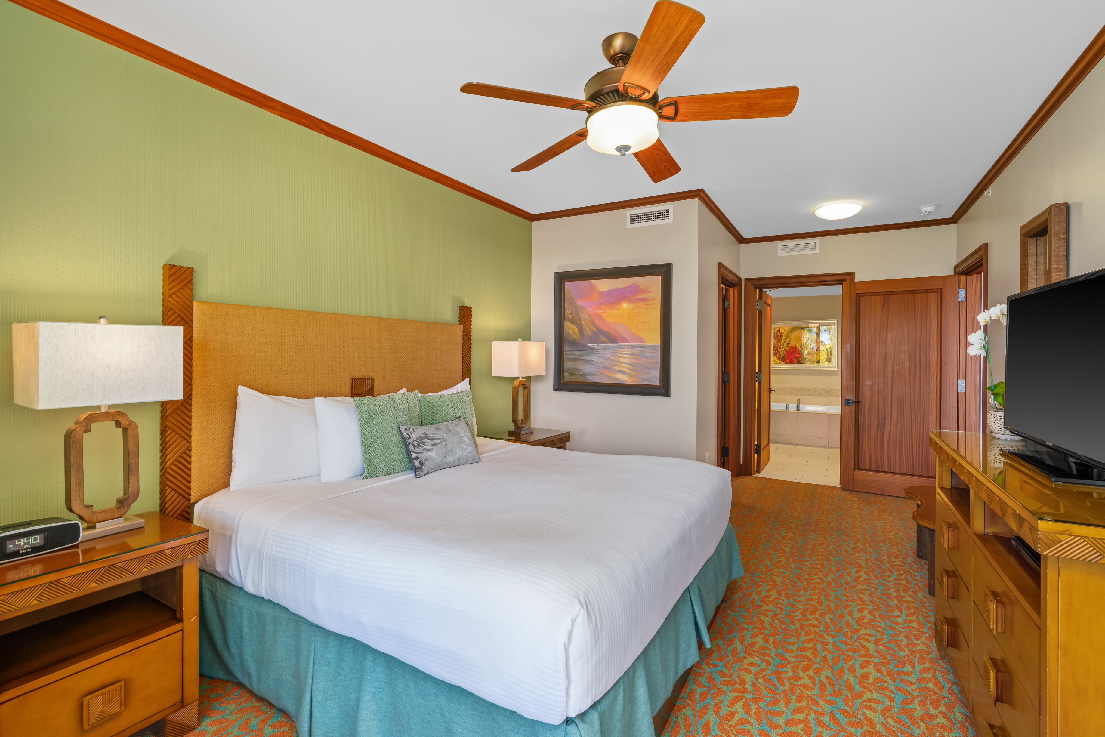 2641 Poipu Road, Unit 1202 Koloa, HI 96756 - Photo 16 of 30 a bedroom with a bed a flat screen tv and a chandelier