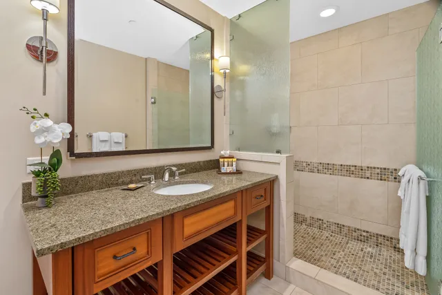 a bathroom with a granite countertop sink and a mirror