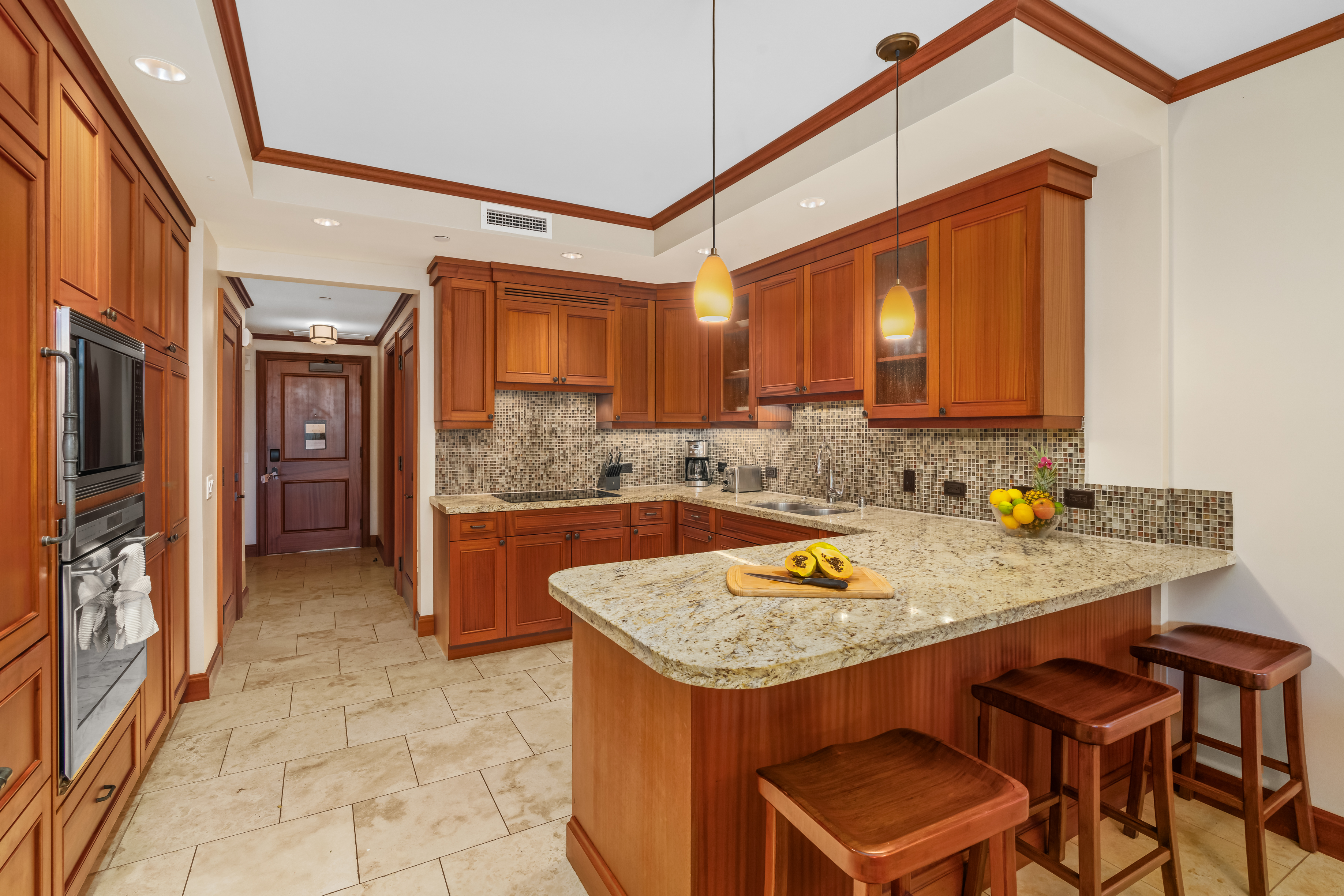 2641 Poipu Road, Unit 1202 Koloa, HI 96756 - Photo 8 of 30 a kitchen with a sink a counter and chairs