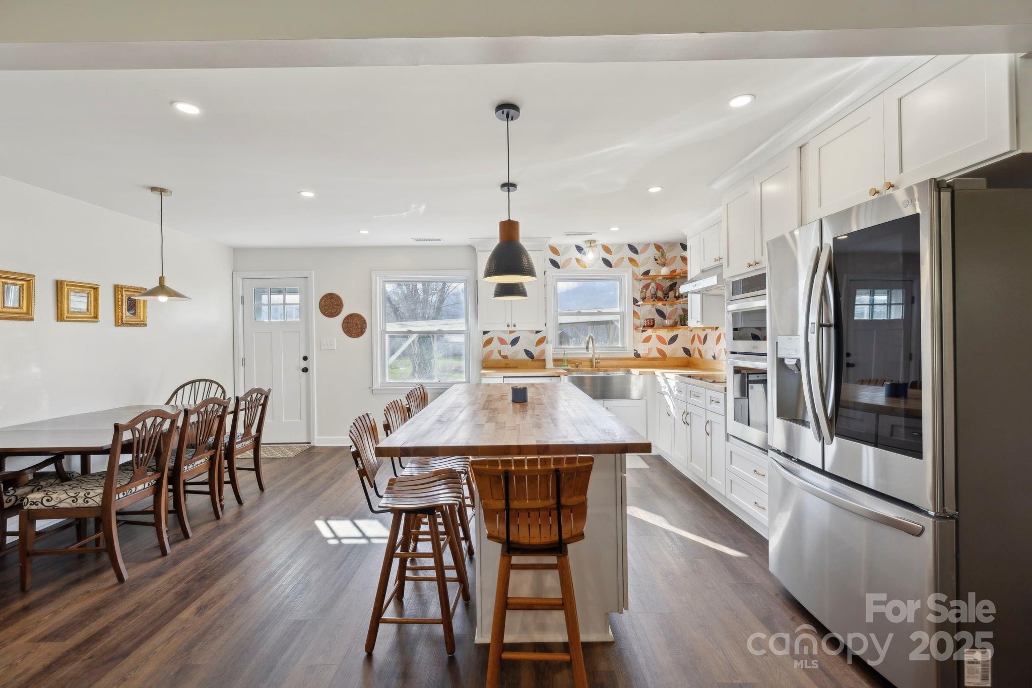 1450 Cane Creek Road Fletcher, NC 28732 - Photo 14 of 36 a kitchen with stainless steel appliances a dining table chairs stove refrigerator and cabinets
