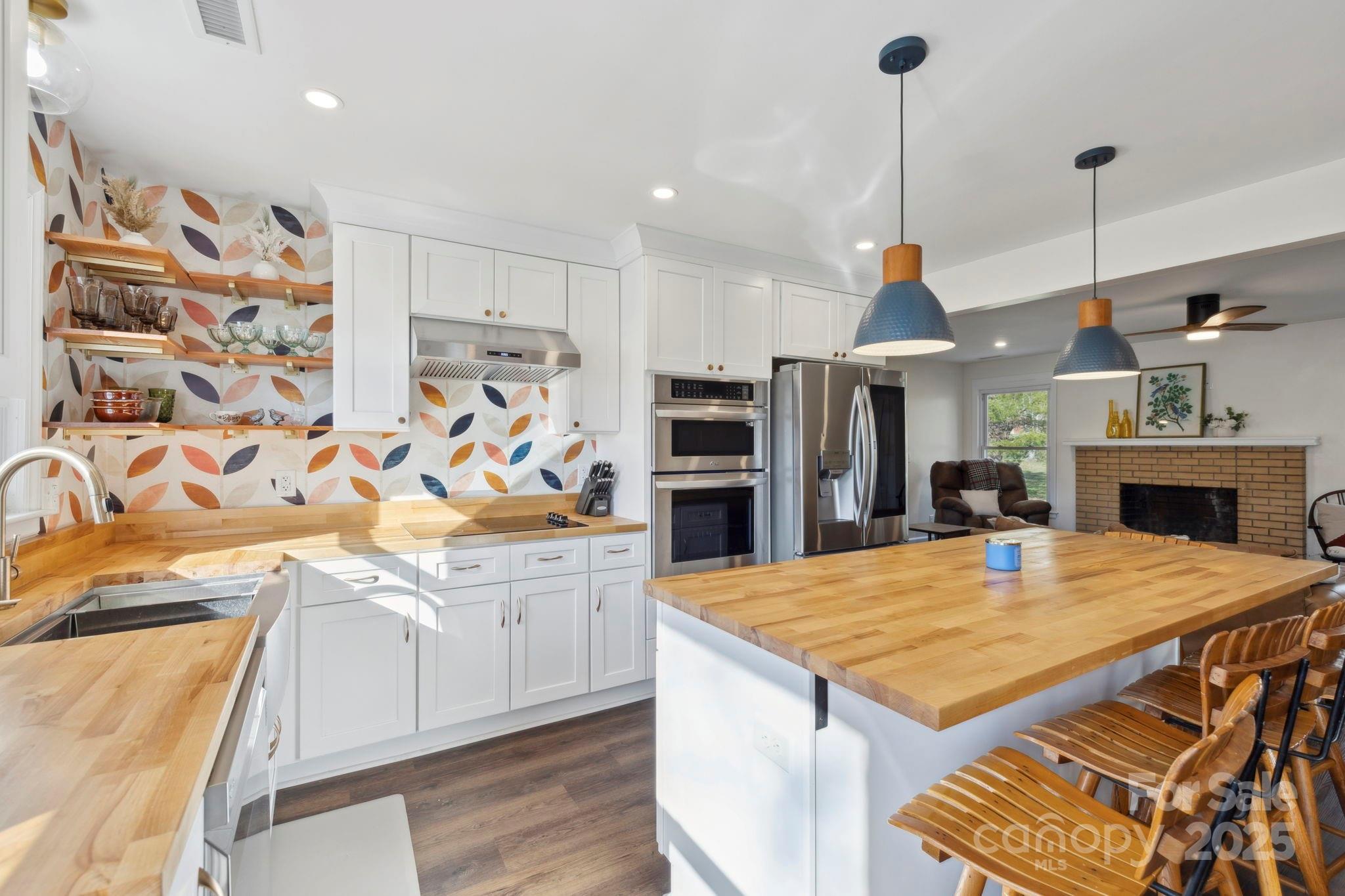 1450 Cane Creek Road Fletcher, NC 28732 - Photo 2 of 36 a kitchen with stainless steel appliances kitchen island granite countertop a table chairs in it and wooden floors