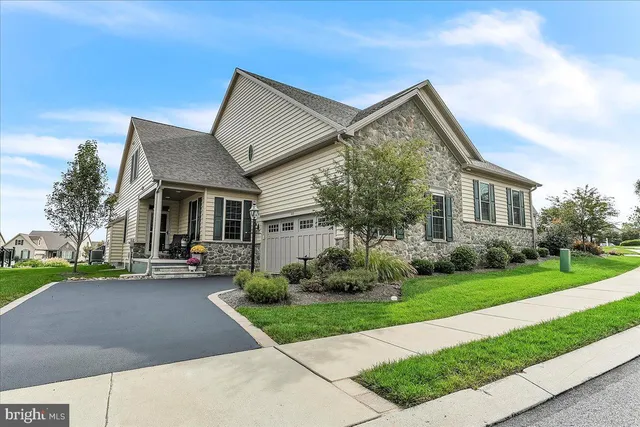 a front view of a house with a yard and potted plants