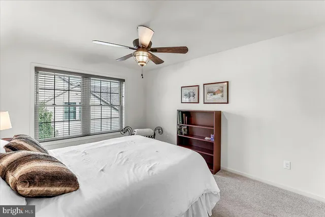 a bedroom with a bed and a large window