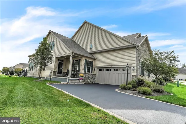 a front view of a house with a garden and trees