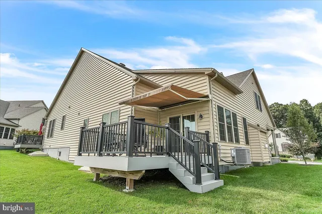 a view of a house with a yard and deck