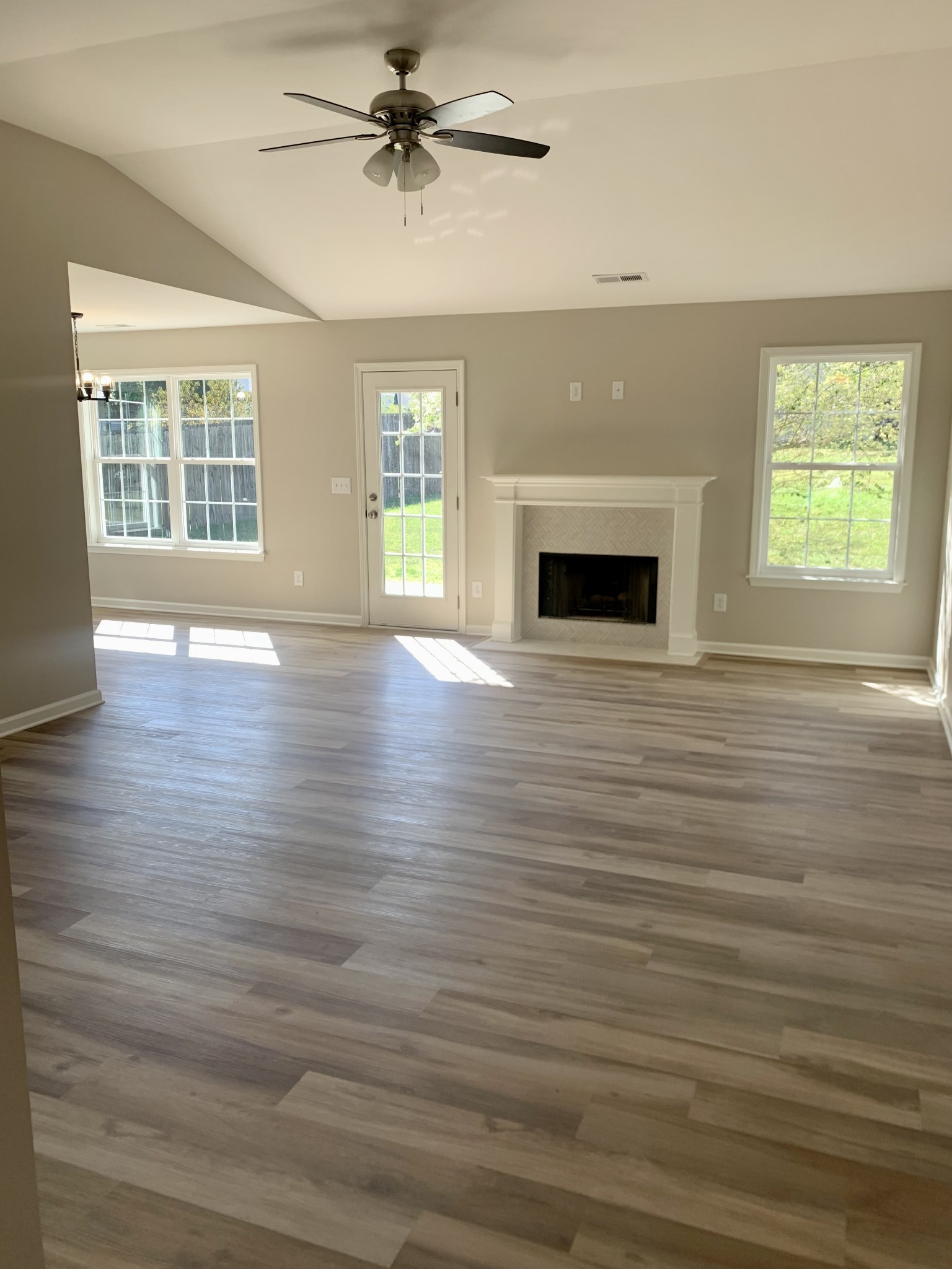 1897 Portway Road Spring Hill, TN 37174 - Photo 3 of 27 an empty room with wooden floor a fireplace and windows