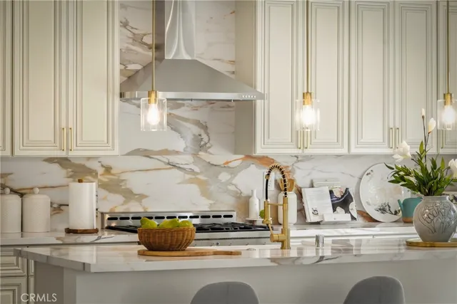 a kitchen with stainless steel appliances granite countertop a sink a stove a refrigerator and white cabinets with wooden floor