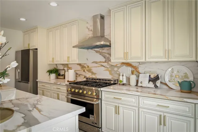 a kitchen with stainless steel appliances kitchen island granite countertop a dining table chairs and white cabinets