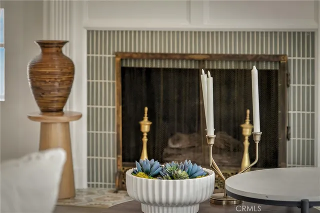 a living room with a fireplace and potted plants
