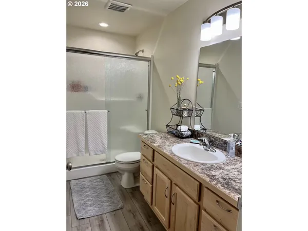 a bathroom with a granite countertop sink toilet and shower