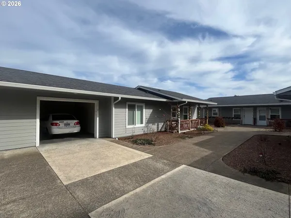 a front view of a house with yard and parking space