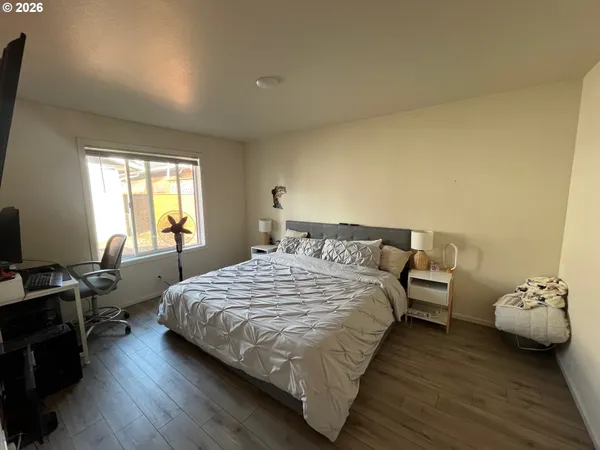 a bedroom with a bed a flat screen tv and guitar