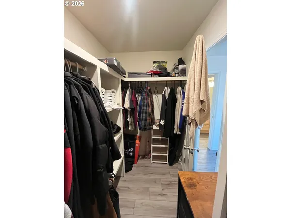 a view of walk in closet with clothes and shoes
