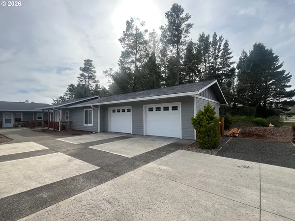 a front view of a house with a yard and trees