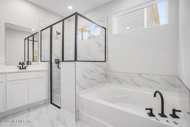 a bathroom with white bath tub and shower