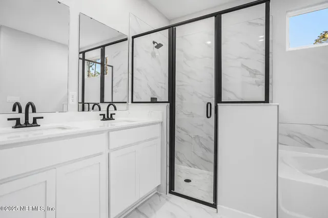 a bathroom with a shower sink and mirror