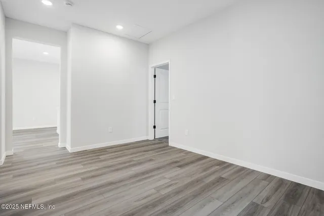 a view of an empty room with wooden floor