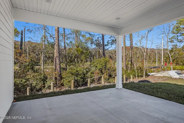 a view of a porch with furniture and a yard