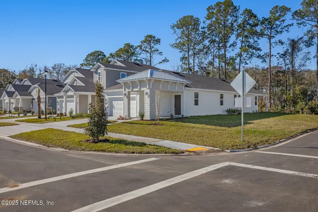 a view of a house with a big yard plants and large trees