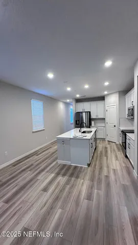 a view of kitchen with refrigerator microwave and stove