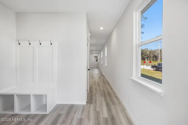 a view of a hallway with wooden floor and staircase