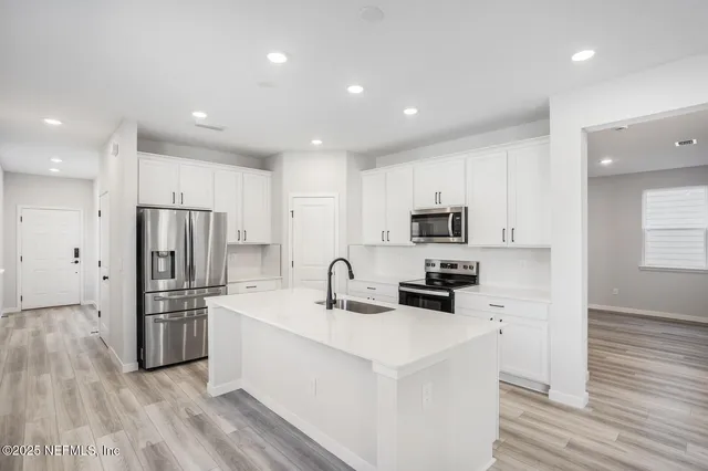 a kitchen with a refrigerator a sink and cabinets