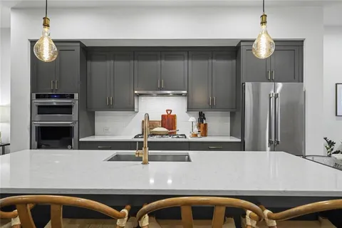 a kitchen with stainless steel appliances granite countertop a refrigerator and a stove