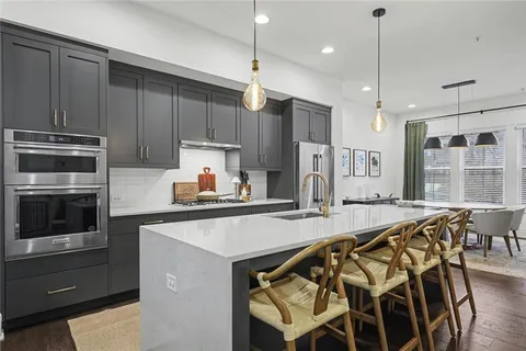 a kitchen with kitchen island a large counter top space appliances and cabinets