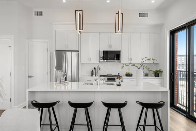 a kitchen with appliances cabinets and chairs