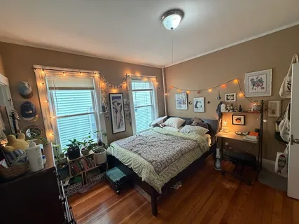 a bedroom with a bed and wooden floor
