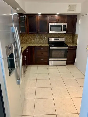 a kitchen with stainless steel appliances granite countertop wooden cabinets a stove top oven a sink and dishwasher