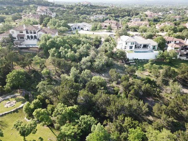 an aerial view of residential houses with outdoor space and trees