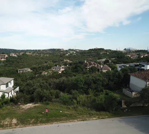 an aerial view of residential house with outdoor space and trees all around