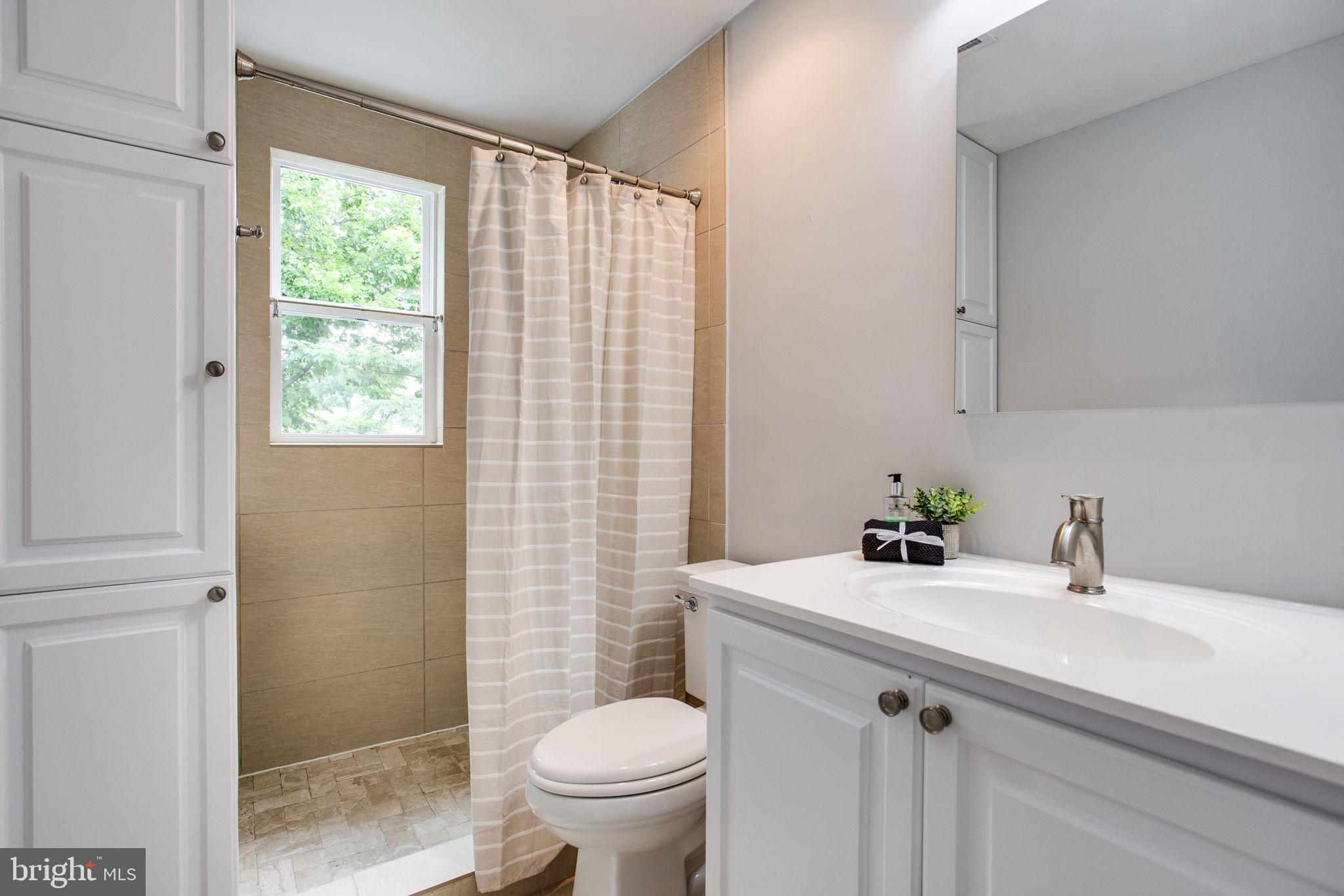 241 Warren Street Northeast Washington, DC 20002 - Photo 22 of 43 Updated tiled bathroom has linen storage + vanity