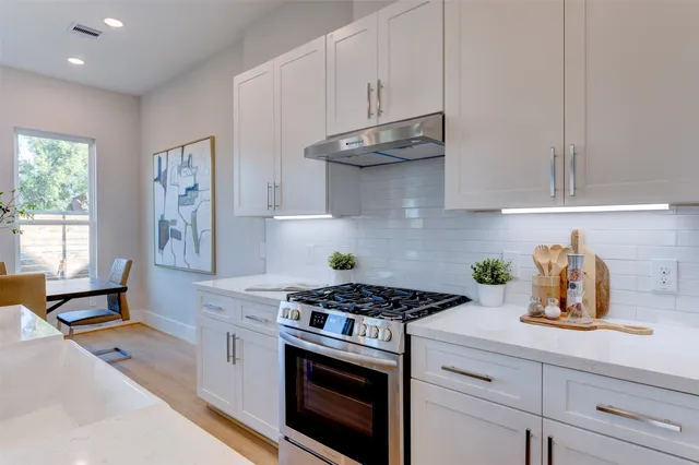 a kitchen with stainless steel appliances granite countertop a sink a stove and a granite counter tops