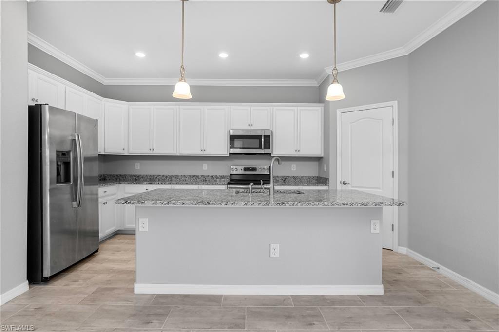 19952 Beverly Park Road Estero, FL 33928 - Photo 6 of 32 a large kitchen with kitchen island a large counter top stainless steel appliances and cabinets