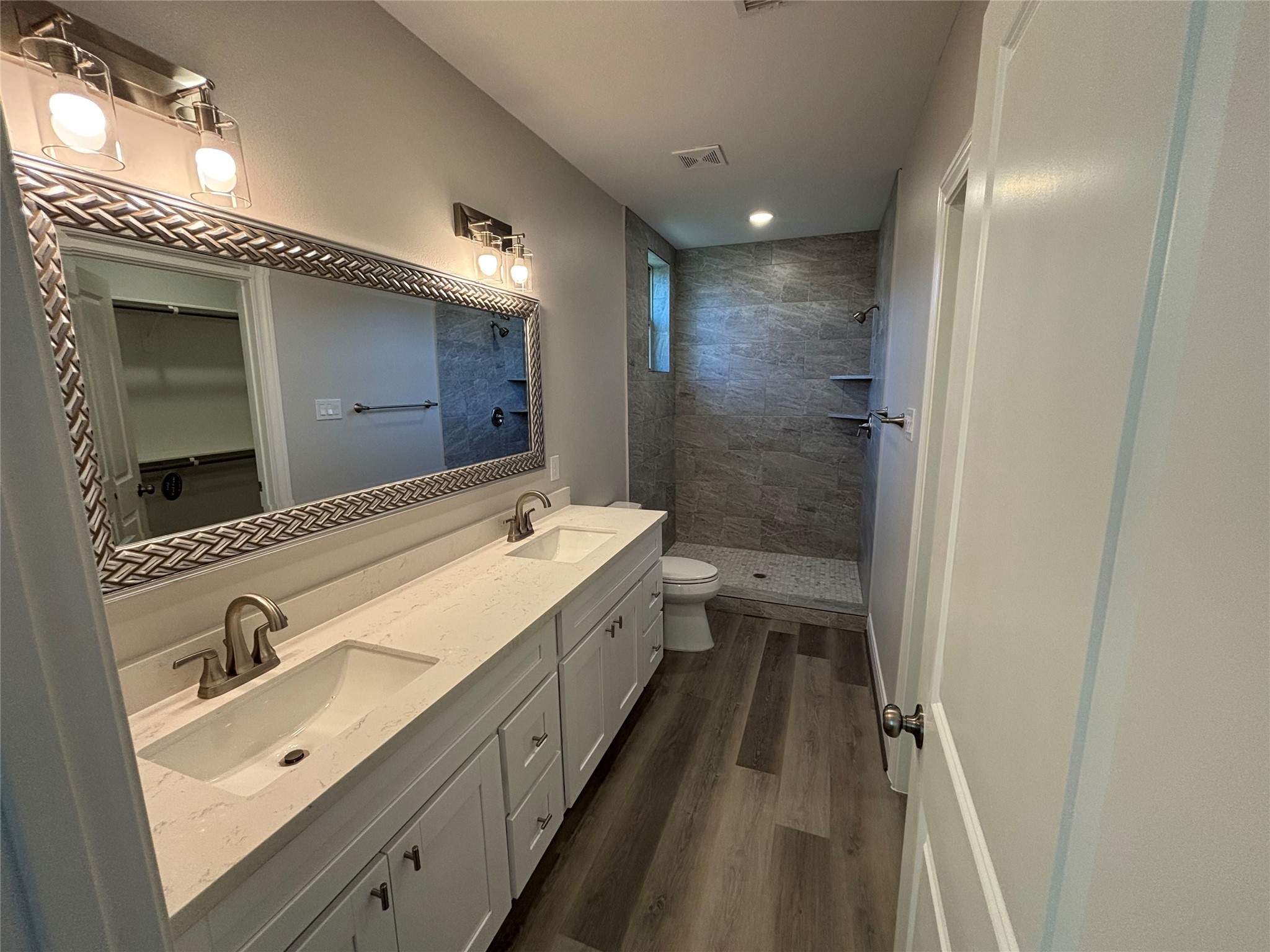 504 Nursery Road, Unit 1108 The Woodlands, TX 77380 - Photo 15 of 25 a bathroom with a double vanity sink and mirror with shower
